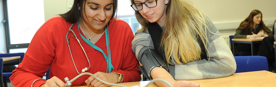 Extended Diploma in Health & Social Care Students Looking at Stethoscope